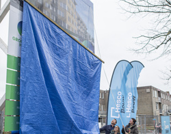 Bouwbord met impressie van het nieuwe appartementencomplex aan de Winkelhoek in Hoogezand.