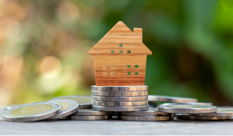 Huis op stapeltje muntgeld